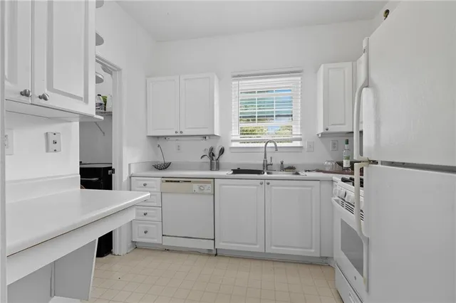 a kitchen with white cabinets and white appliances