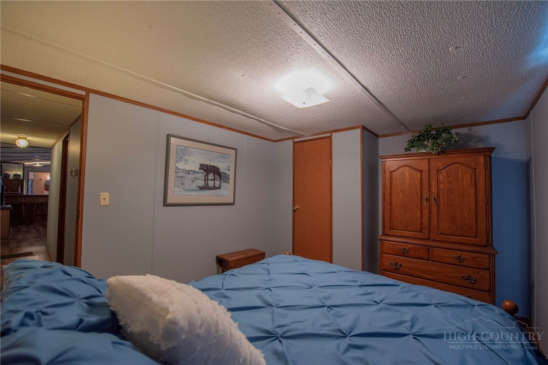 1848 West Mill Creek Road Warrensville, NC 28693 - Photo 37 of 50 a bedroom with a bed and cabinets