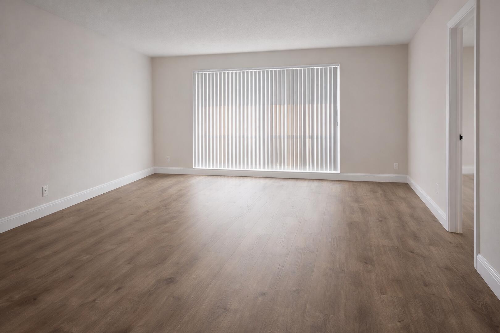 541 Northeast 48th Street, Unit 205 Boca Raton, FL 33431 - Photo 2 of 8 a view of an empty room with wooden floor and a window