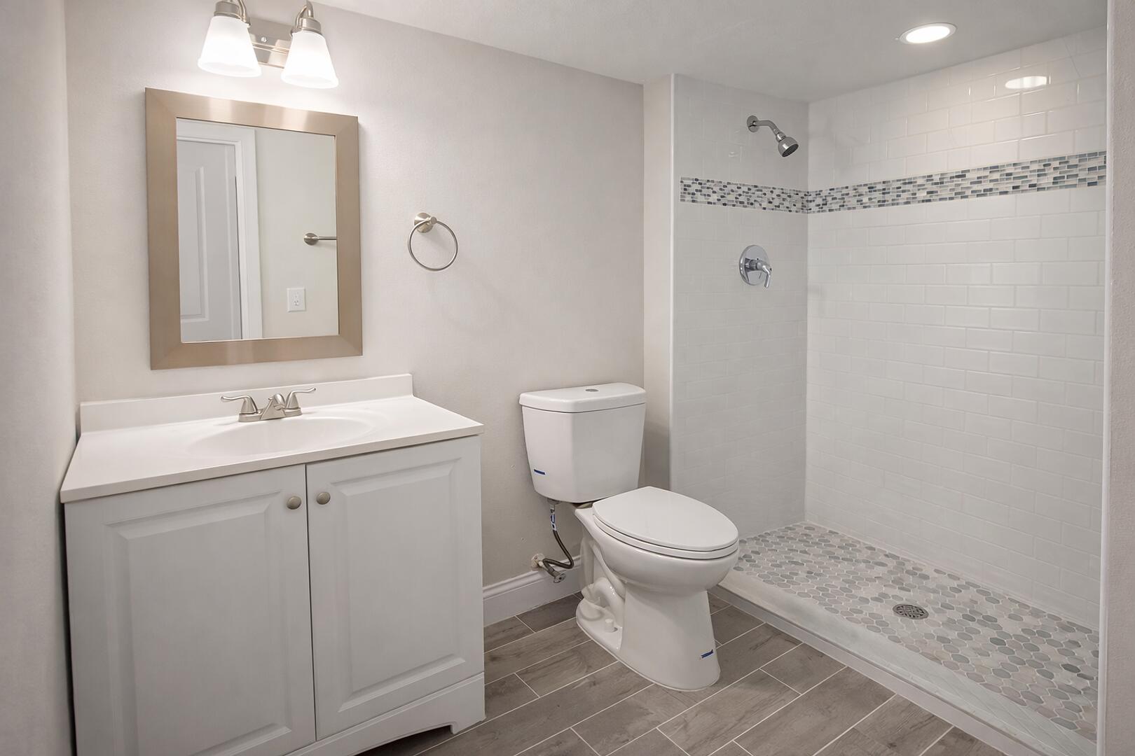 541 Northeast 48th Street, Unit 205 Boca Raton, FL 33431 - Photo 4 of 8 a bathroom with a sink a toilet a mirror and shower