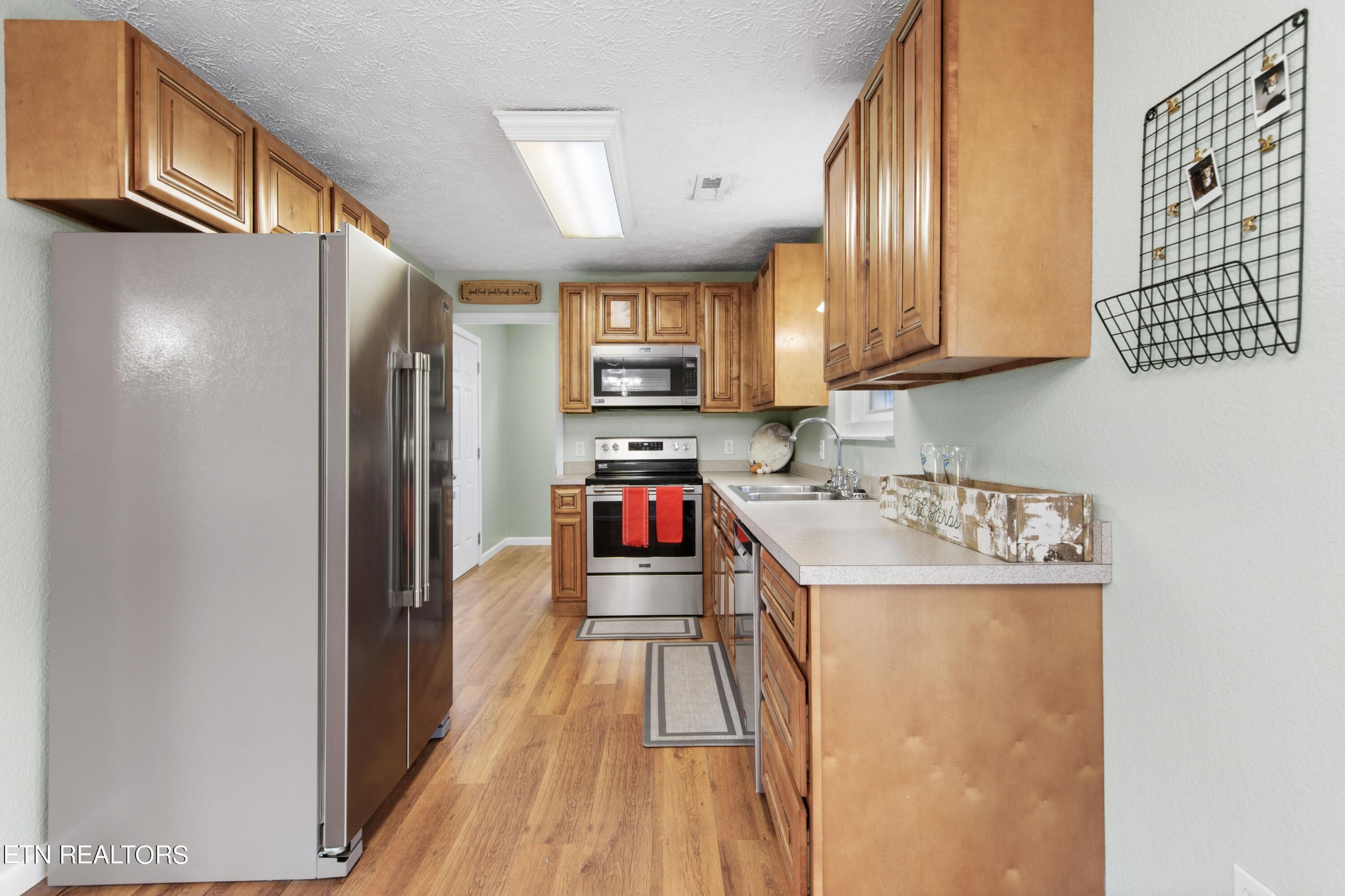 2252 Shinbone Road Sevierville, TN 37876 - Photo 10 of 27 a kitchen with stainless steel appliances granite countertop a refrigerator a stove and a sink with wooden floor