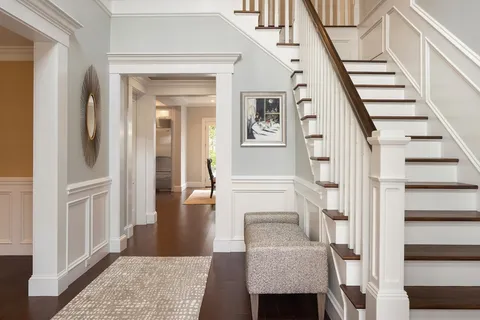 a view of a hallway with wooden floor and staircase