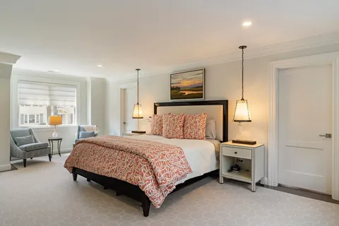 a bedroom with a bed a table and painting