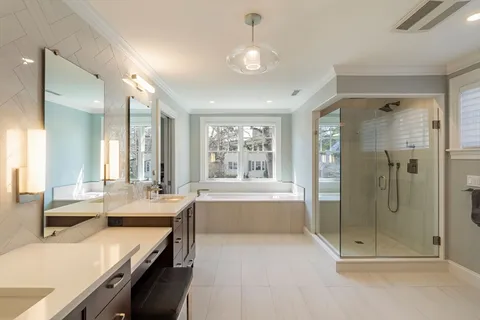 a large white kitchen with a large window and stainless steel appliances