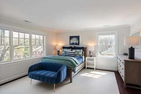 a bedroom with a bed and a large window