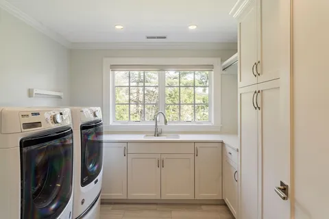 a view of a kitchen with a sink a washer and dryer