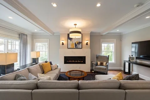 a living room with furniture a fireplace and a flat screen tv