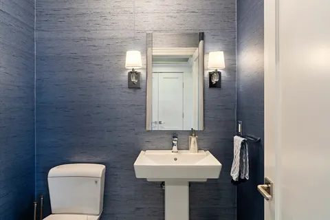 a bathroom with a toilet sink and mirror