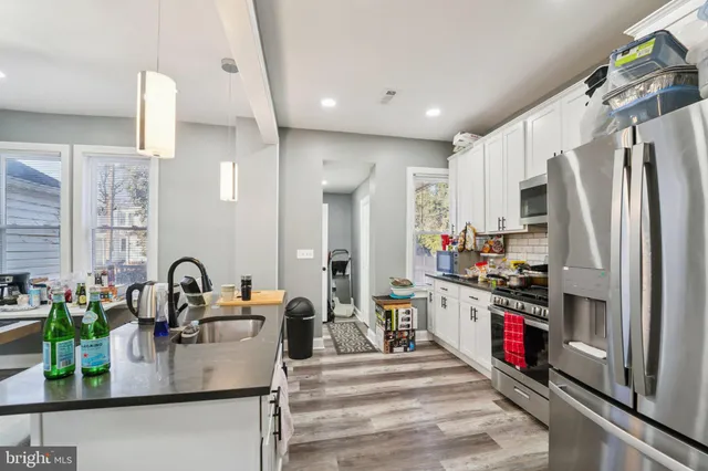 a kitchen with granite countertop a sink stainless steel appliances and cabinets