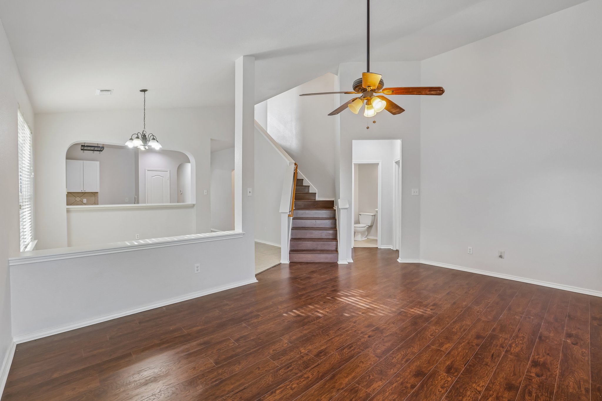 1721 Long Rifle Drive Austin, TX 78754 - Photo 6 of 38 Rich hardwood floors extend through this spacious living area with an elegant staircase and archway to the kitchen.