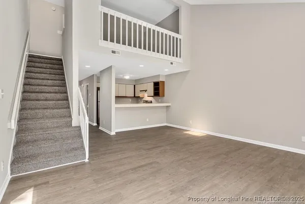 a view of a hallway with entryway and wooden floor