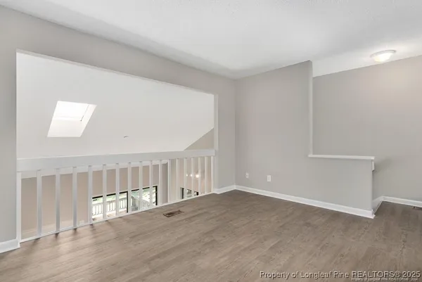 a view of an empty room with wooden floor
