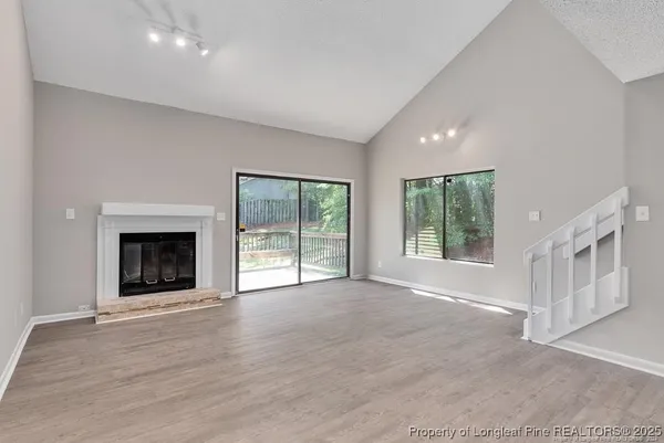 a view of an empty room with a window and fireplace