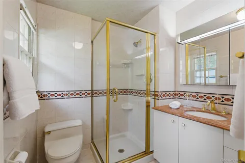 a bathroom with a granite countertop sink mirror vanity and toilet