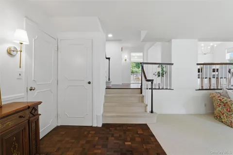 a view of entryway with kitchen and wooden floor