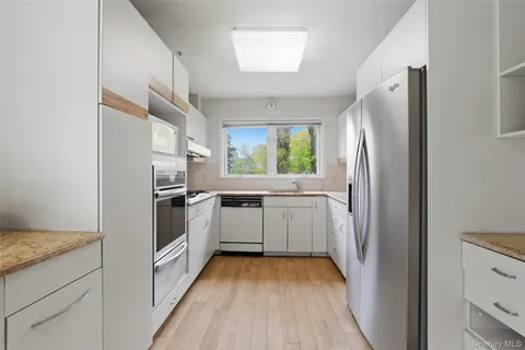 a kitchen with a refrigerator a sink and dishwasher a oven with wooden floor
