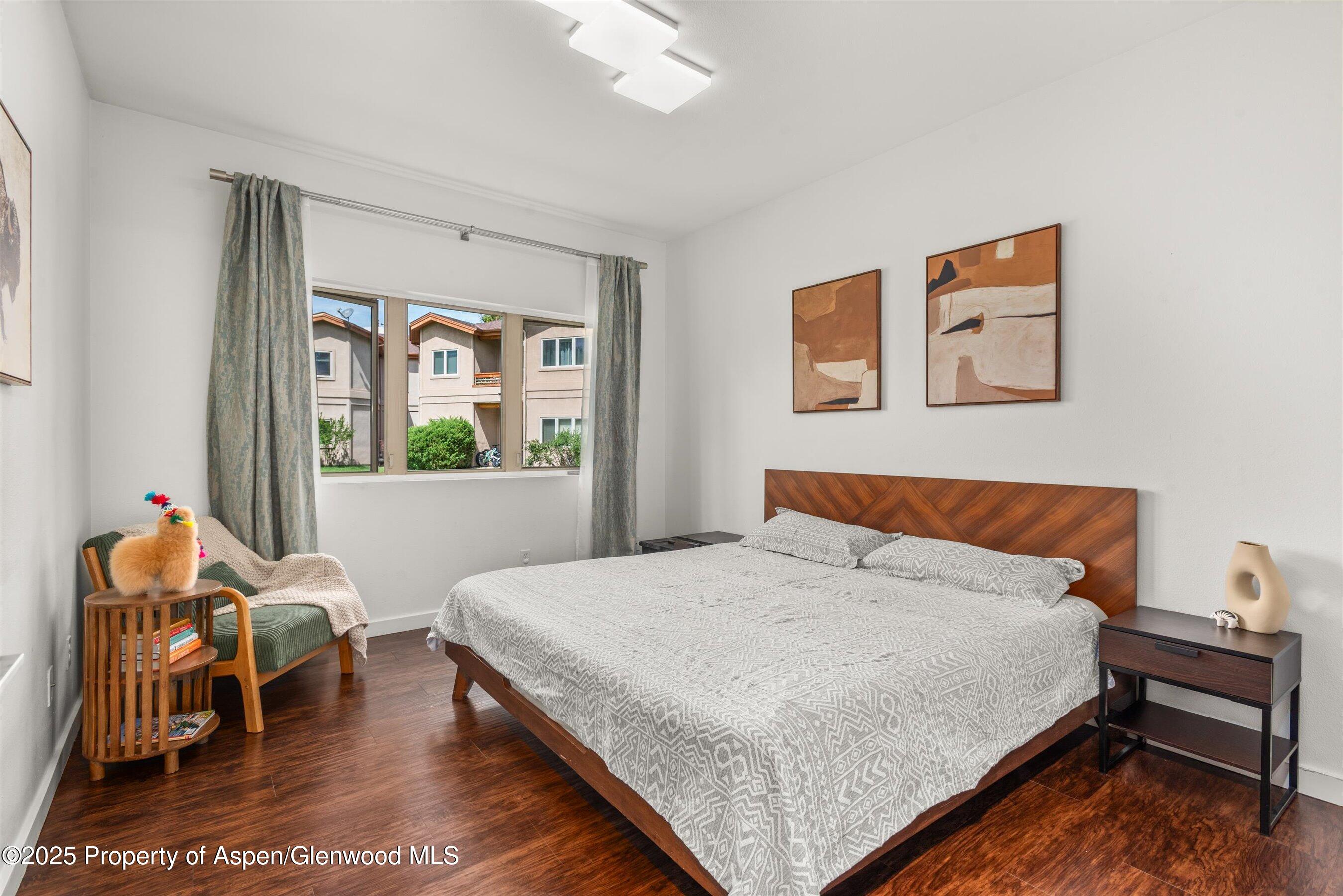 1400 East Valley Road, Unit 115 Basalt, CO 81621 - Photo 12 of 17 a bedroom with a bed and wooden floor