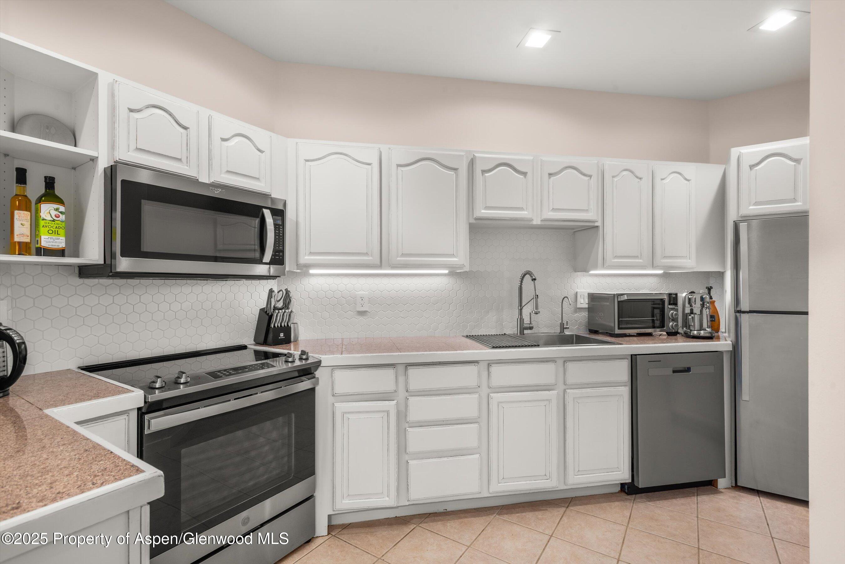 1400 East Valley Road, Unit 115 Basalt, CO 81621 - Photo 9 of 17 a kitchen with cabinets stainless steel appliances and a sink
