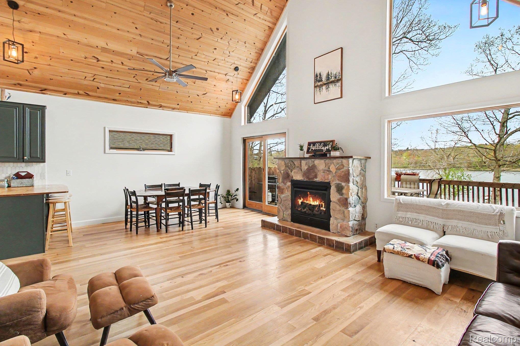 4375 Skinner Lake Road Lapeer, MI 48446 - Photo 8 of 30 Living room with a vaulted wooden ceiling, light wood-style flooring, a stone fireplace, and a ceiling fan