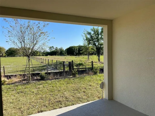 an empty room with yard from a window