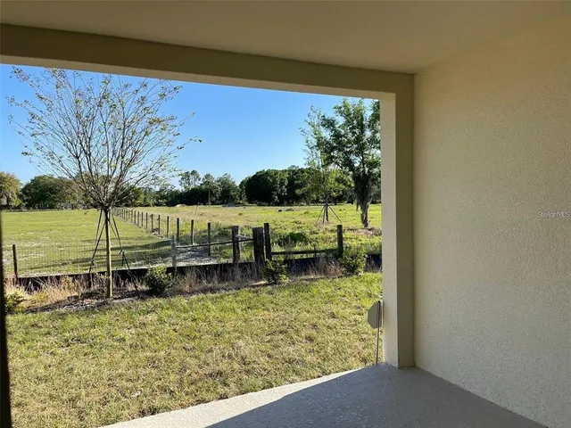 an empty room with yard from a window