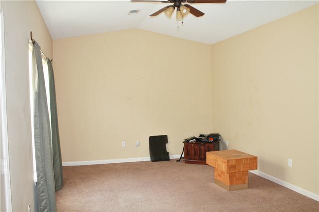 Large living area with vaulted ceiling that opens into kitchen