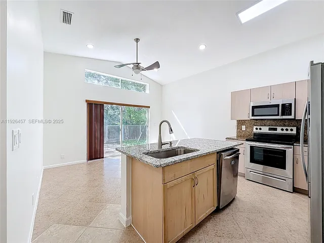 a kitchen with a sink appliances and cabinets