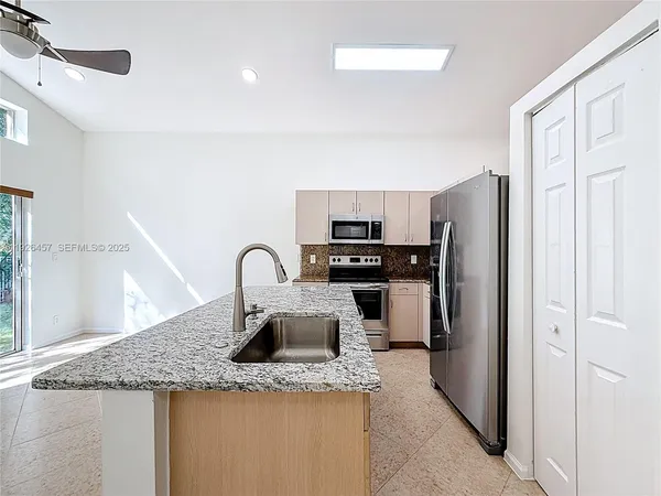 a kitchen with stainless steel appliances granite countertop a refrigerator and a sink