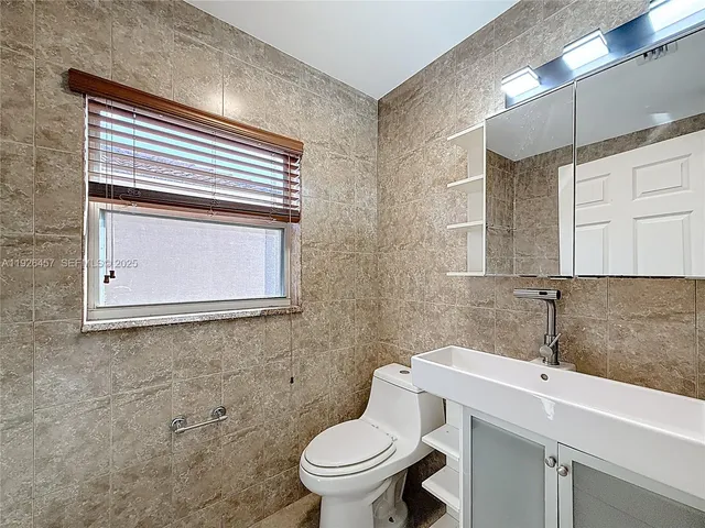 a bathroom with a toilet a sink and mirror