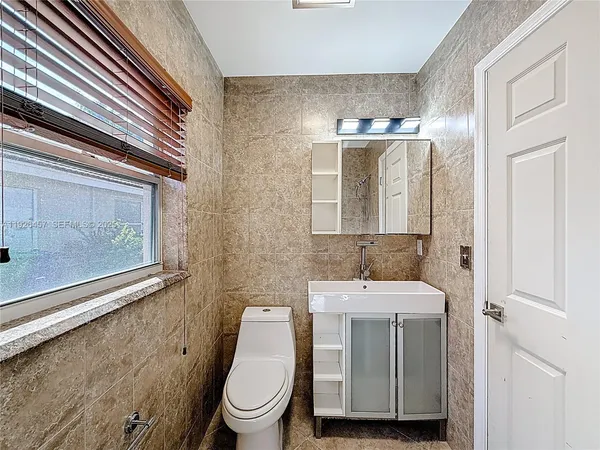 a bathroom with a sink toilet and mirror