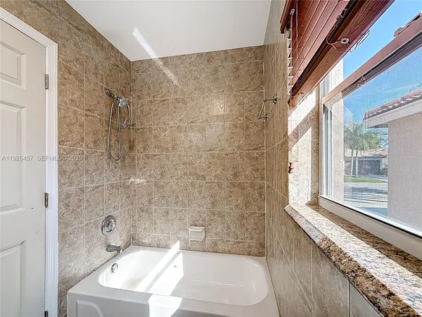 a bathroom with a sink a toilet a window and bathtub