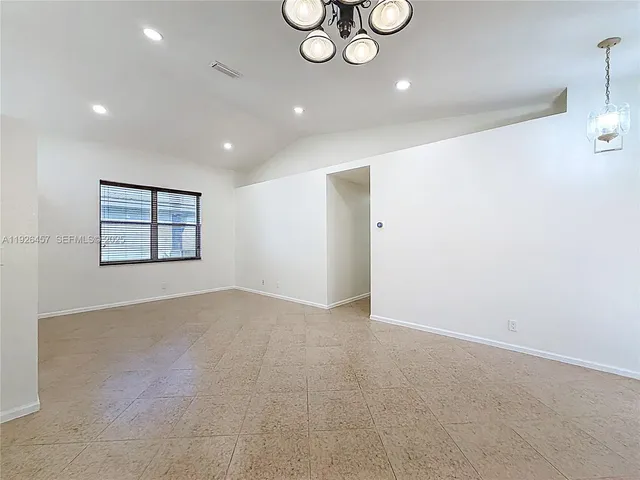 an empty room with windows and ceiling fan