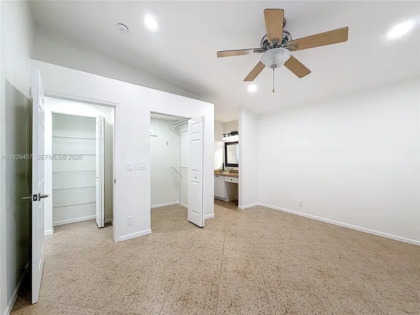 an empty room with closet and windows