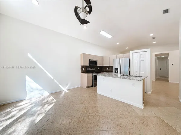 a kitchen with stainless steel appliances kitchen island a refrigerator and a stove top oven