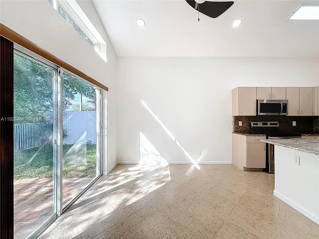 a view of kitchen with microwave and refrigerator