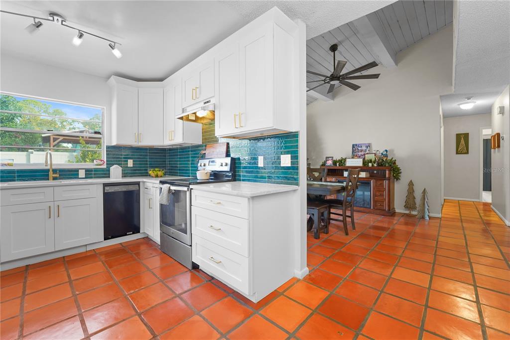 7523 Barry Road Tampa, FL 33634 - Photo 11 of 28 a kitchen with stainless steel appliances kitchen island granite countertop a table chairs and a refrigerator