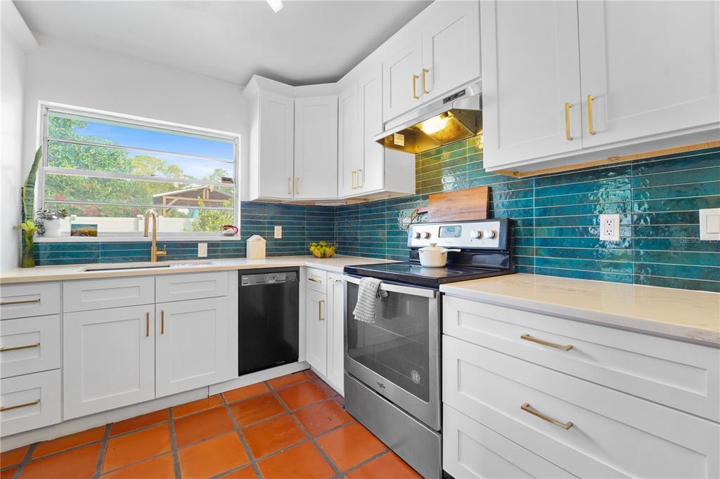 7523 Barry Road Tampa, FL 33634 - Photo 12 of 28 a kitchen with stainless steel appliances granite countertop a stove a sink and white cabinets