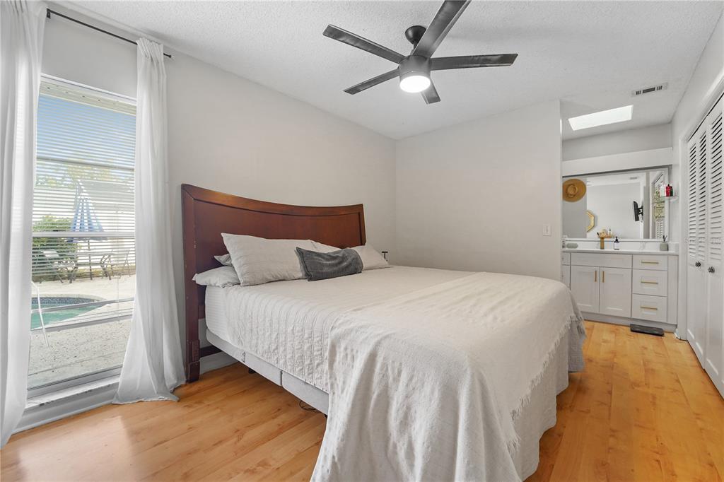 7523 Barry Road Tampa, FL 33634 - Photo 17 of 28 a bedroom with a large bed and a chandelier