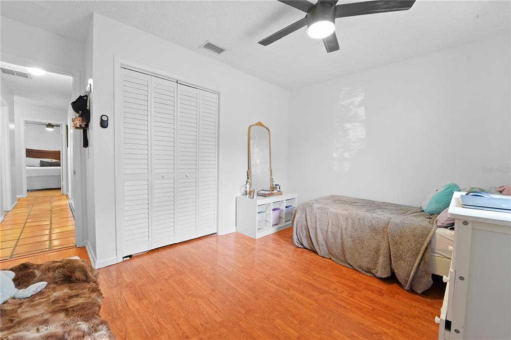 7523 Barry Road Tampa, FL 33634 - Photo 22 of 28 a bedroom with a bed and a dresser