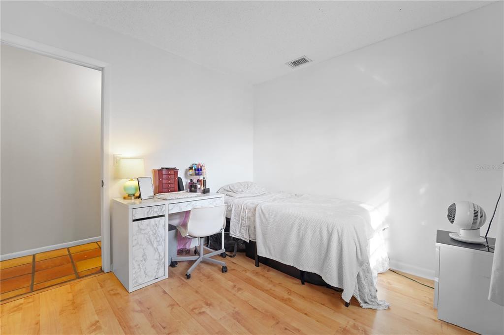 7523 Barry Road Tampa, FL 33634 - Photo 23 of 28 a bedroom with a bed and a desk