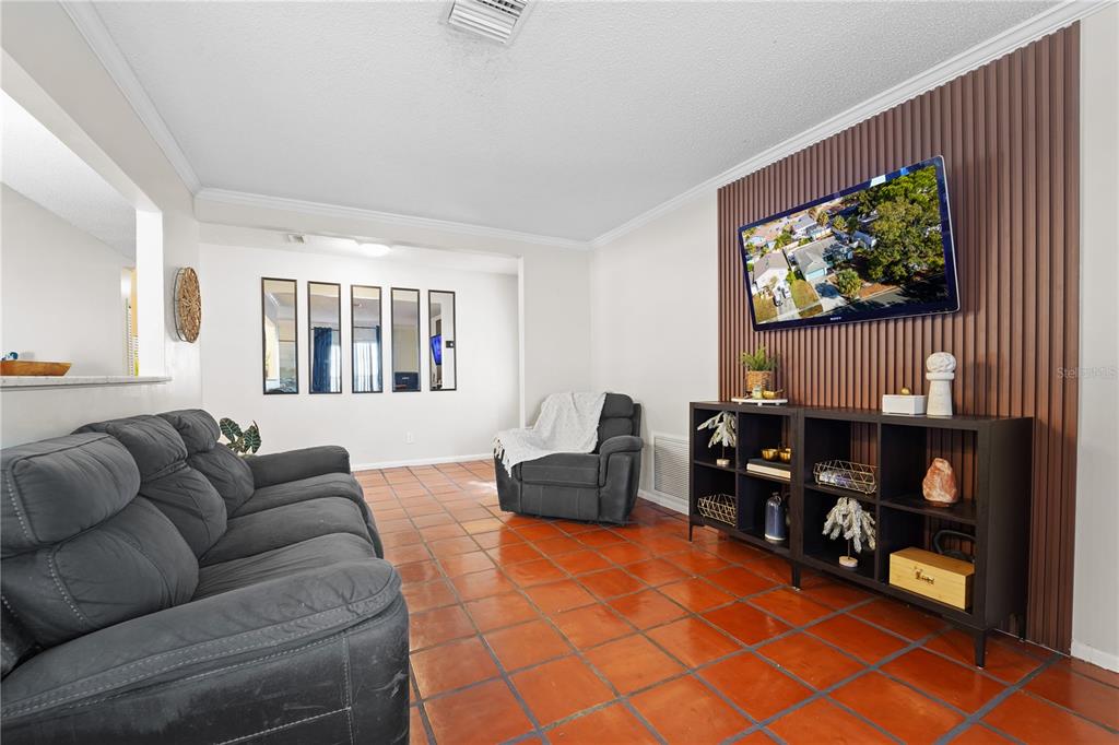 7523 Barry Road Tampa, FL 33634 - Photo 8 of 28 a living room with furniture a flat screen tv and a window