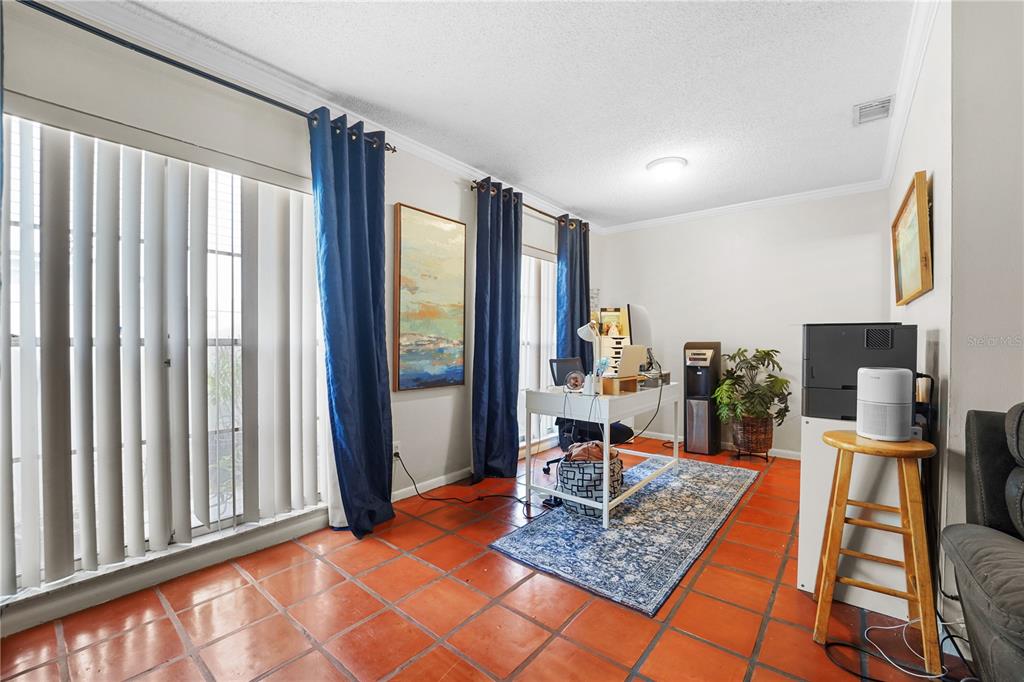 7523 Barry Road Tampa, FL 33634 - Photo 10 of 28 a work room with furniture and a flat screen tv