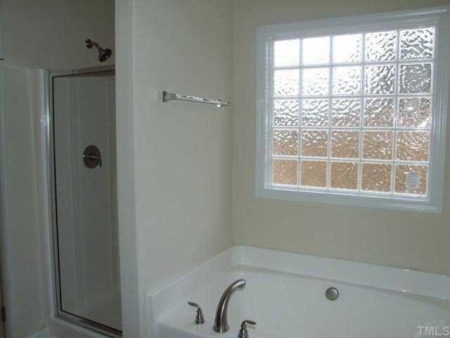 2215 Stoney Spring Drive Raleigh, NC 27610 - Photo 10 of 12 a bathroom with a bathtub and next to a window