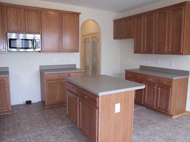 2215 Stoney Spring Drive Raleigh, NC 27610 - Photo 4 of 12 a kitchen with stainless steel appliances granite countertop wooden cabinets a sink and a stove