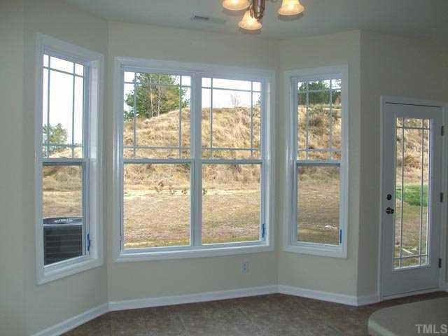 2215 Stoney Spring Drive Raleigh, NC 27610 - Photo 5 of 12 a view of an empty room with wooden floor and windows
