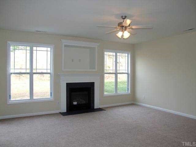 2215 Stoney Spring Drive Raleigh, NC 27610 - Photo 6 of 12 an empty room with chandelier fan and windows