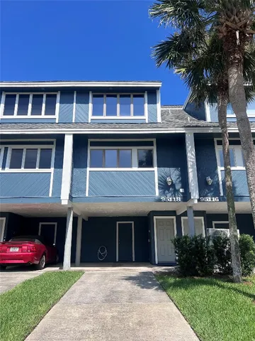 a front view of a house with a yard and potted plants