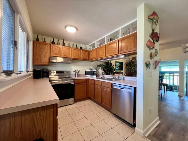 a kitchen with stainless steel appliances granite countertop a refrigerator and a stove top oven
