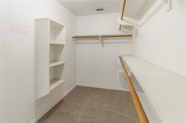 a view of walk in closet with empty racks