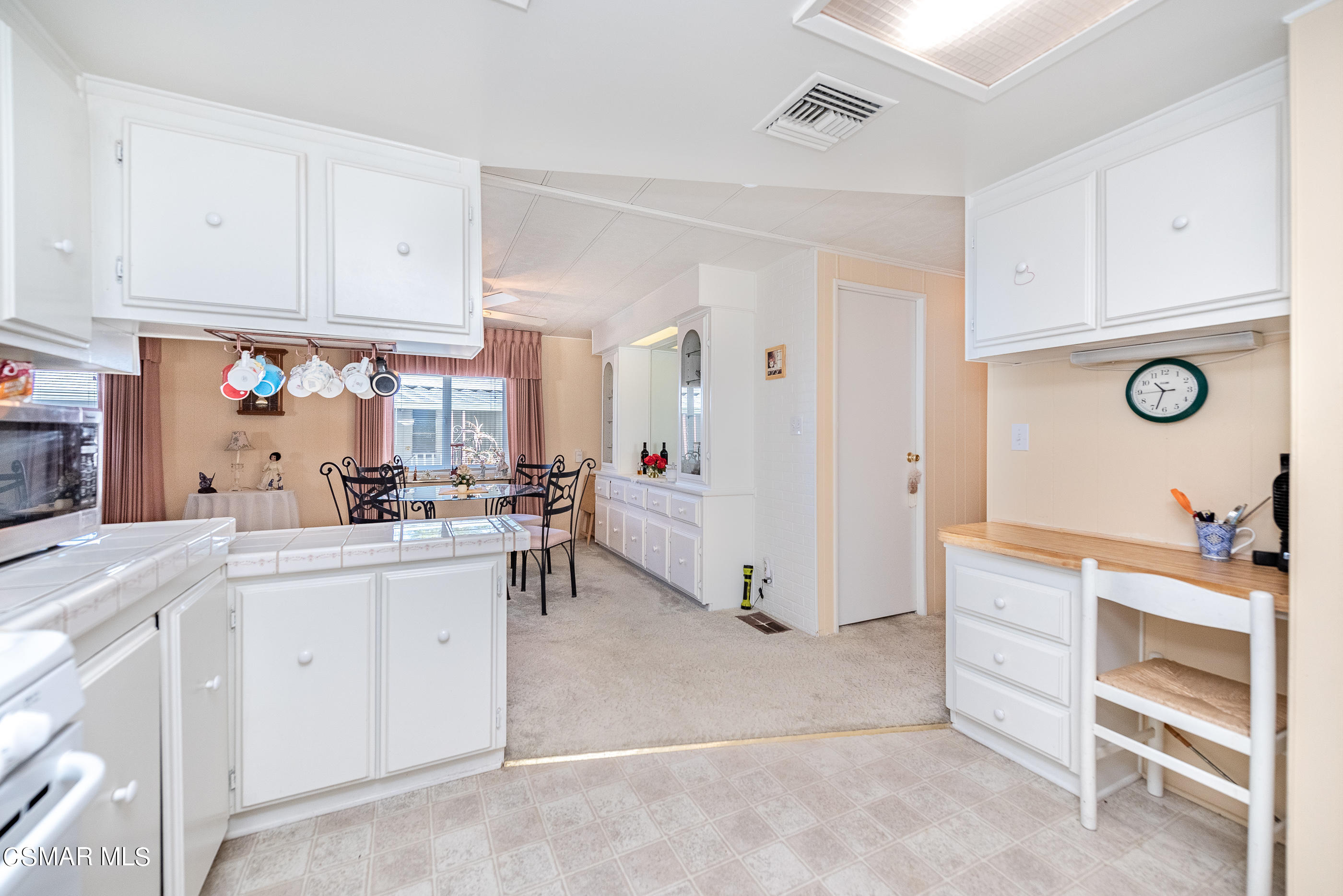 6480 Katherine Road, Unit 114 Simi Valley, CA 93063 - Photo 14 of 25 a kitchen with white cabinets and white appliances
